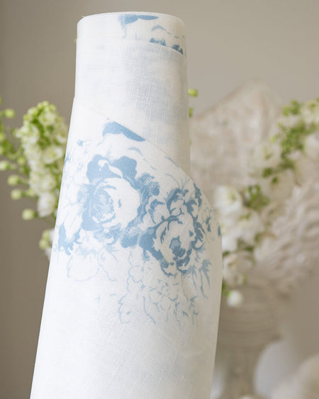 Roll of oilcloth with blue floral design against a neutral background