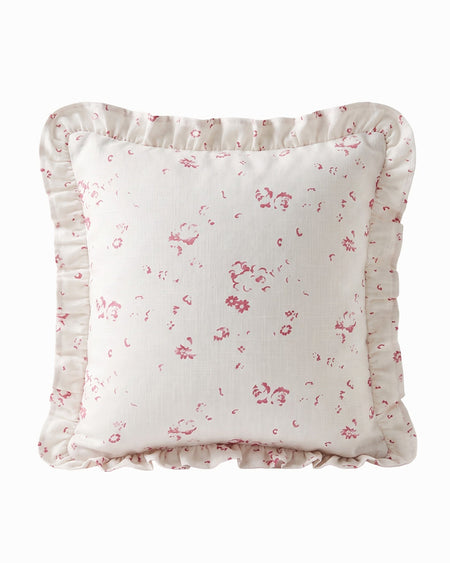 Floral patterned pillow with ruffled edge on a white background