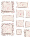 Set of decorative pillows with floral patterns and ruffled edges on a light background