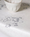 White ceramic bowl on a textured white surface with floral patterns
