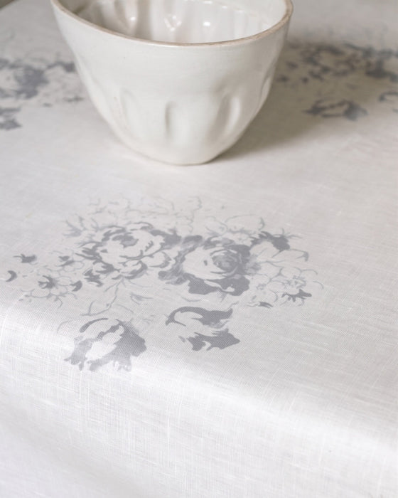White ceramic bowl on a textured white surface with floral patterns