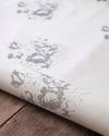 Roll of fabric with floral pattern on a wooden surface