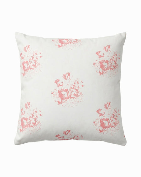 White pillow with pink floral pattern on a white background