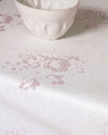 White ceramic bowl on a white surface with a subtle floral pattern