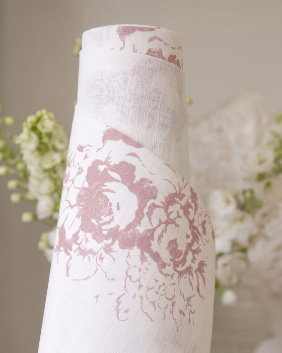 White vase with pink floral pattern against a blurred floral background