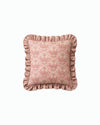Pink patterned pillow with ruffled edges on a white background