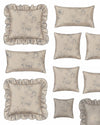 Set of decorative pillows with floral patterns and ruffled edges on a neutral background.