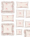 Set of decorative pillows with floral patterns and ruffled edges on a white background.