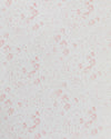 Close-up of white linen fabric with a subtle pink floral print.