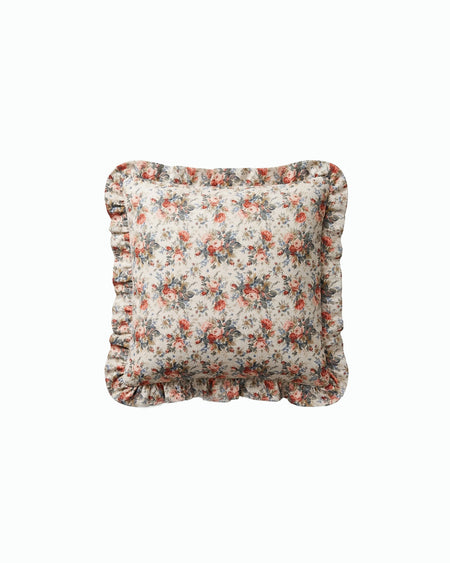 Floral patterned cushion with ruffled edges on a white background